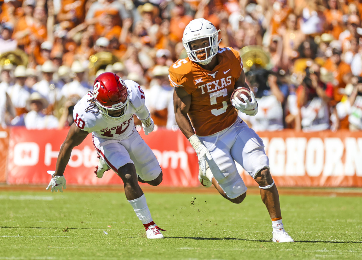 Oct 9, 2021; Dallas, Texas, USA; Texas Longhorns running back Bijan Robinson (5) runs with the ball as Oklahoma Sooners safety Pat Fields (10) defends during the game at the Cotton Bowl.